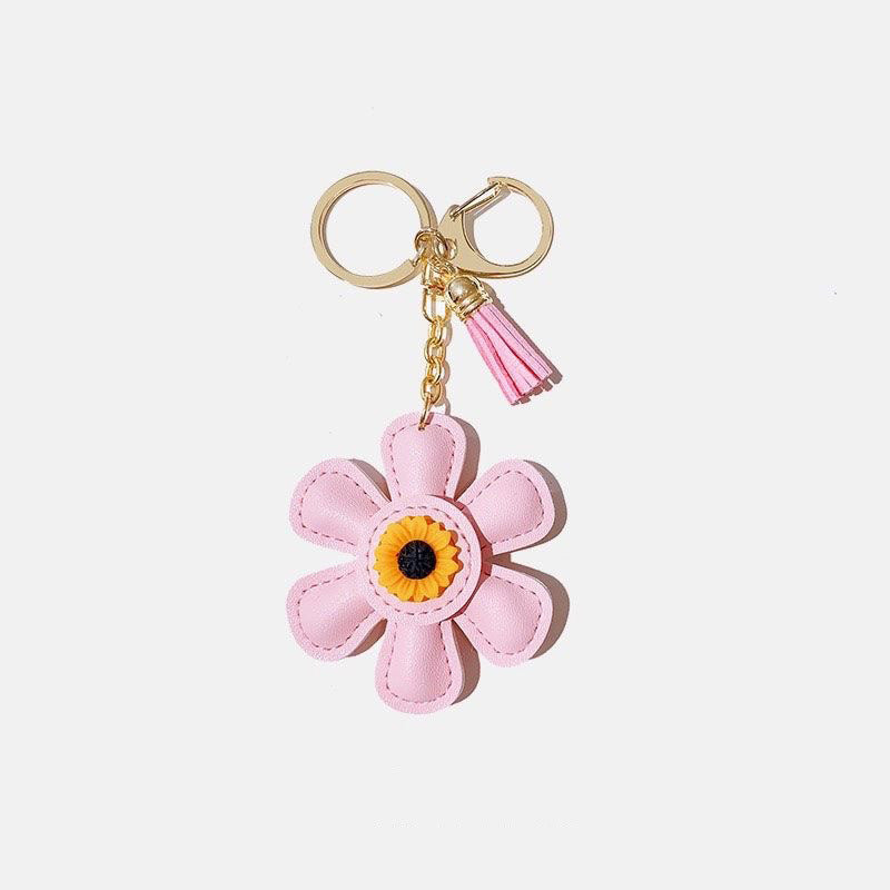 A vibrant pink PU leather sunflower keychain with a gold clasp, perfect for decorating bags and keys.