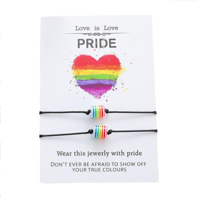 A pair of handmade adjustable pride bracelets with rainbow beads on a presentation card that reads 'Love is Love'.