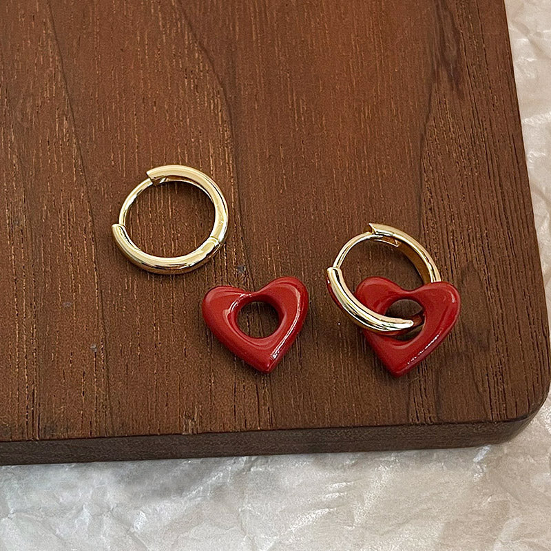 A pair of wholesale red enamel heart pendant earrings with polished gold hoops, made from brass.