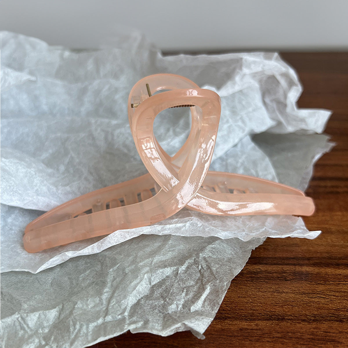 A stylish rose gold acetate hair jaw clip with a unique twisted loop design, perfect for securing long hair.