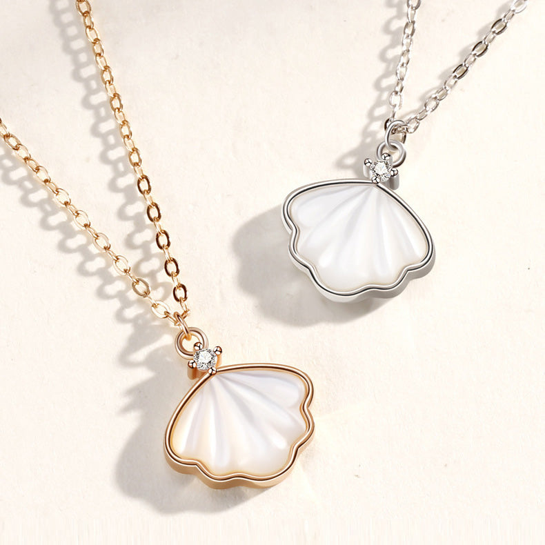 A pair of 925 sterling silver sea shell pendant necklaces, one in a polished silver finish and the other in a warm gold tone, displayed side-by-side.