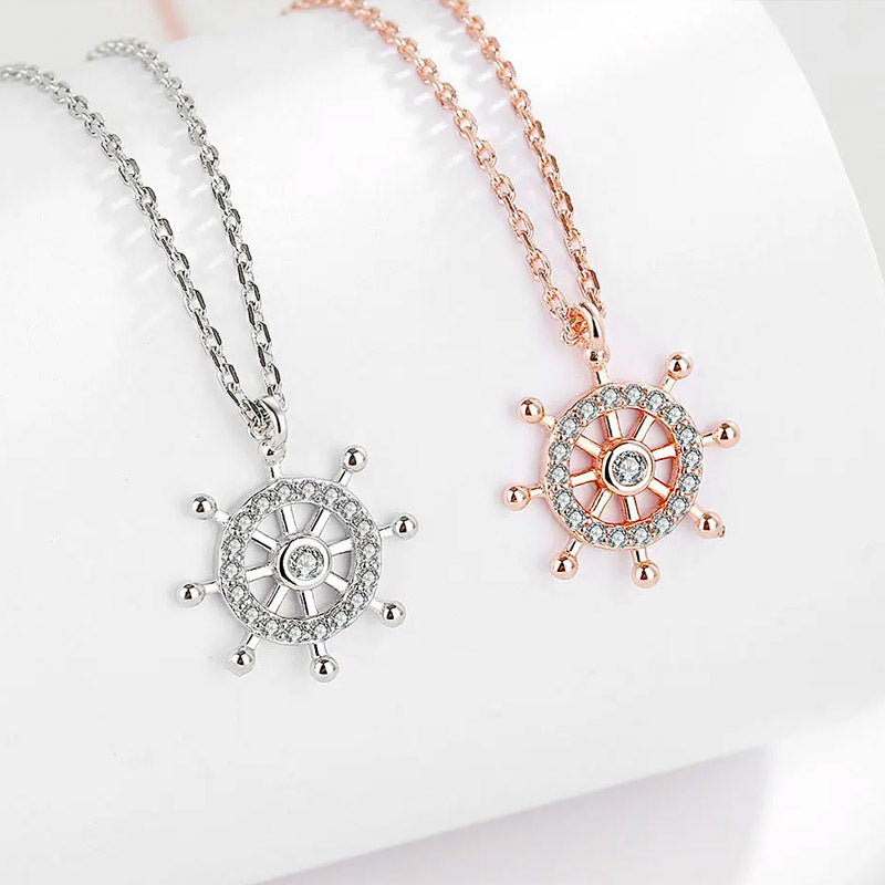 A set of 925 sterling silver ocean voyage necklaces, showcasing both the silver and rose gold ship wheel pendants with sparkling stone accents.