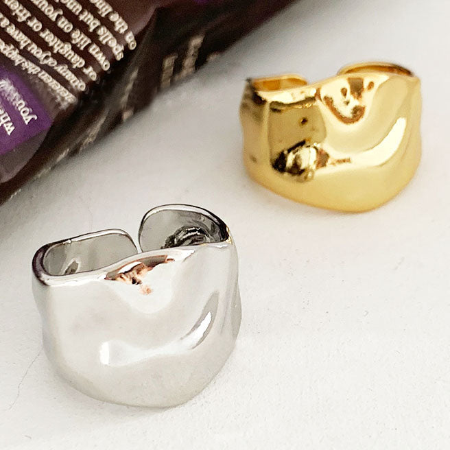 A set of brass irregularly hammered geometric wide band open rings, showcasing both the gold and silver finish options against a clean white background.
