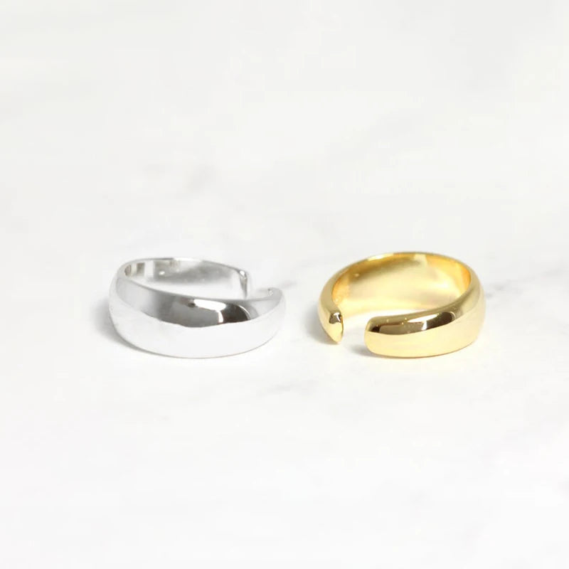 A pair of 925 sterling silver chunky C-shape ear cuffs, one in a polished silver finish and the other in a radiant gold finish, displayed on a clean white background.