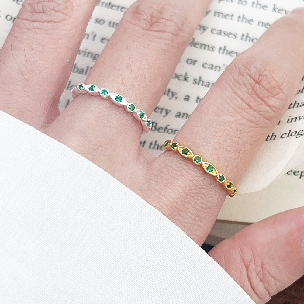A model wearing the wholesale 925 sterling silver open stacking rings with green zircon stones, showcasing both the silver and gold finish options.