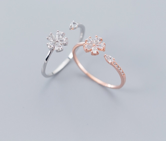 A pair of 925 sterling silver flower rings, one in silver and one in rose gold, both featuring intricate floral designs with sparkling cubic zirconia stones.