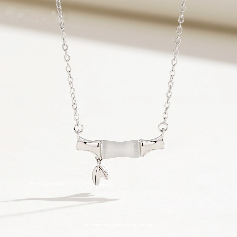 A close-up of a 925 sterling silver necklace from the set, featuring an elegant bamboo-inspired pendant with a white opal stone.