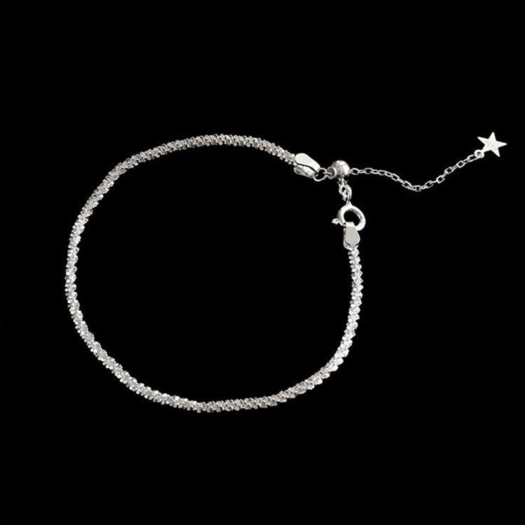 A close-up of a 925 sterling silver bracelet from the crystal bling chain collection, showing its detailed textured links and a star charm.