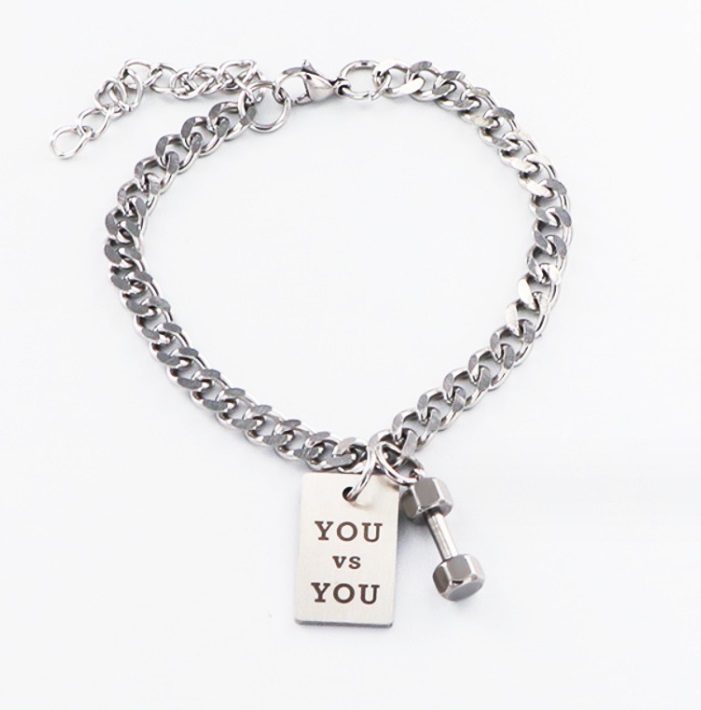 A stainless steel Tumbbell Chain Bracelet for Men, featuring a motivational 'YOU vs YOU' charm and a dumbbell charm, shown on a white background.