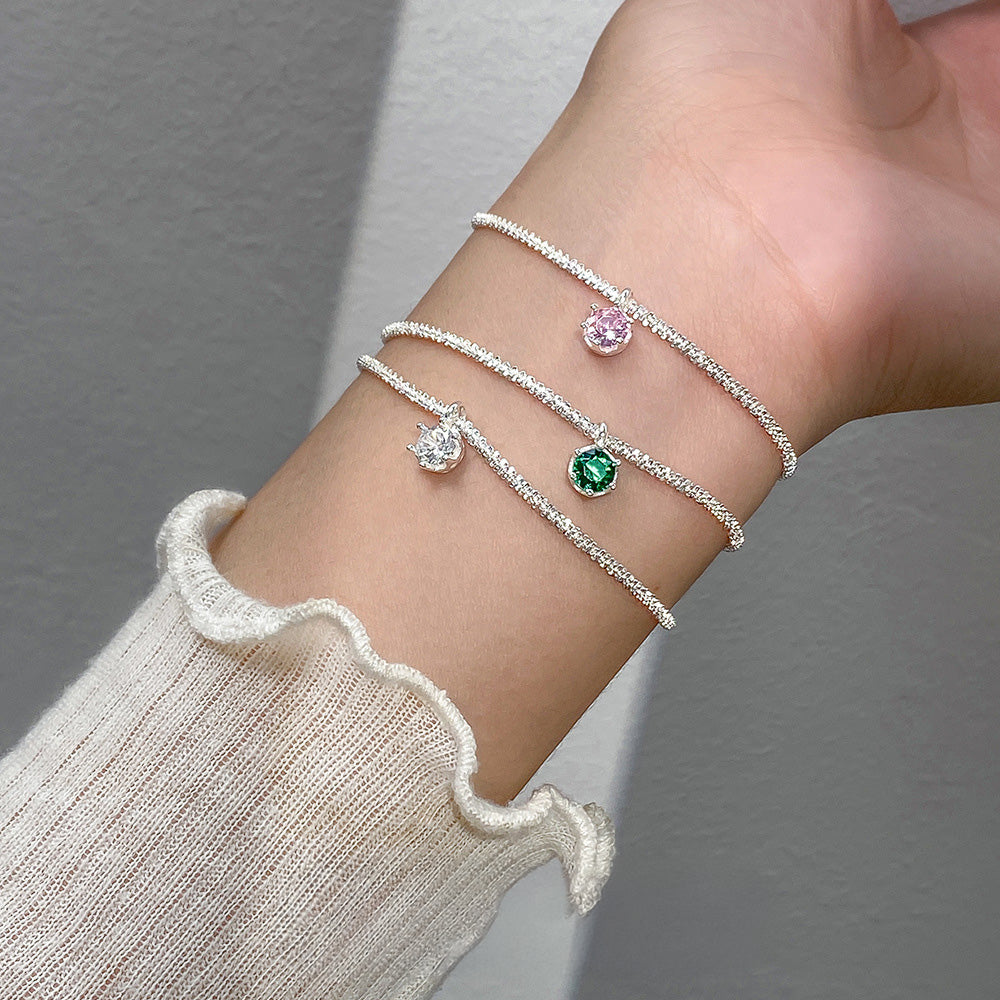 A set of three 925 sterling silver bracelets with sparkling zircon gemstones in white, pink, and green, displayed on a neutral background.