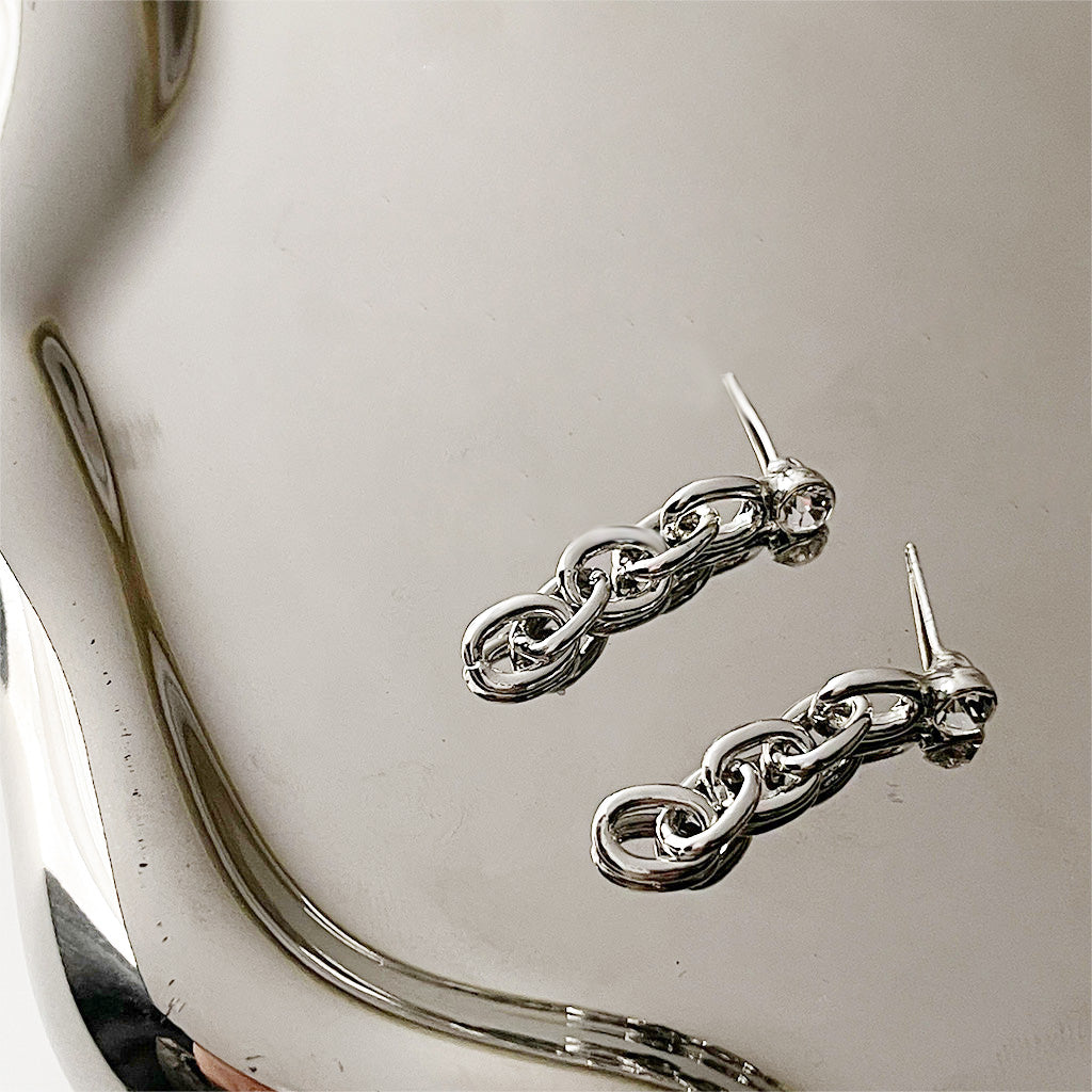 A pair of silver-plated link chain earrings with sparkling zircon drops, displayed on a clean white background.