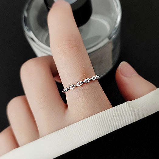 A close-up of a 925 sterling silver adjustable open ring with a link chain design, worn on a person's finger to showcase its elegant fit.