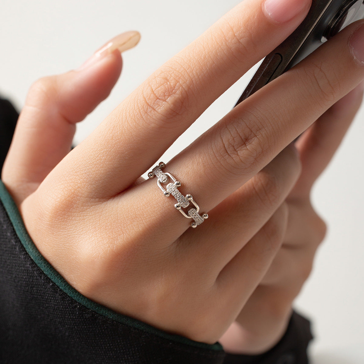 A close-up of the 925 sterling silver CZ U-link chain adjustable ring on a model's finger, highlighting the sparkling stones and intricate link design.