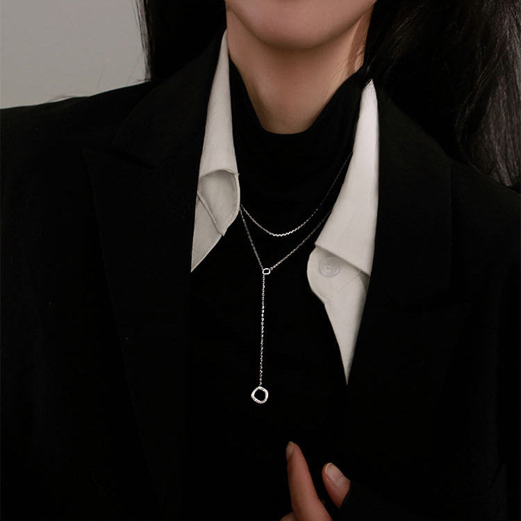 A close-up of two 925 sterling silver necklaces with geometric irregular circle pendants being worn, showcasing their elegant design.