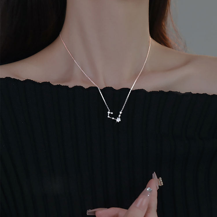 A model wearing the 925 sterling silver constellation pendant necklace, showcasing its elegant design against a black top.