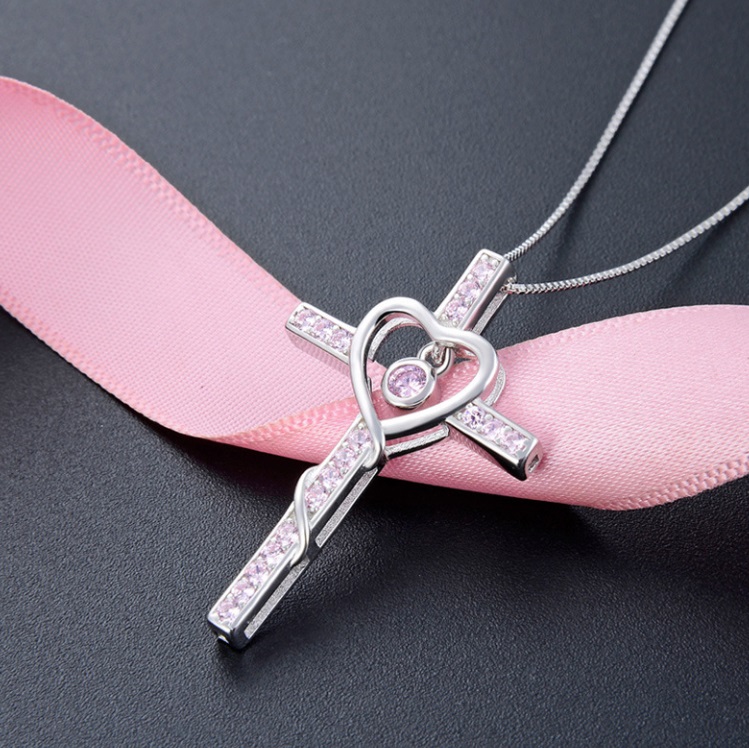 A detailed view of the 925 Sterling Silver Cross Pendant Necklace, featuring a delicate heart-shaped center with pink cubic zirconia, showcasing its fine craftsmanship.