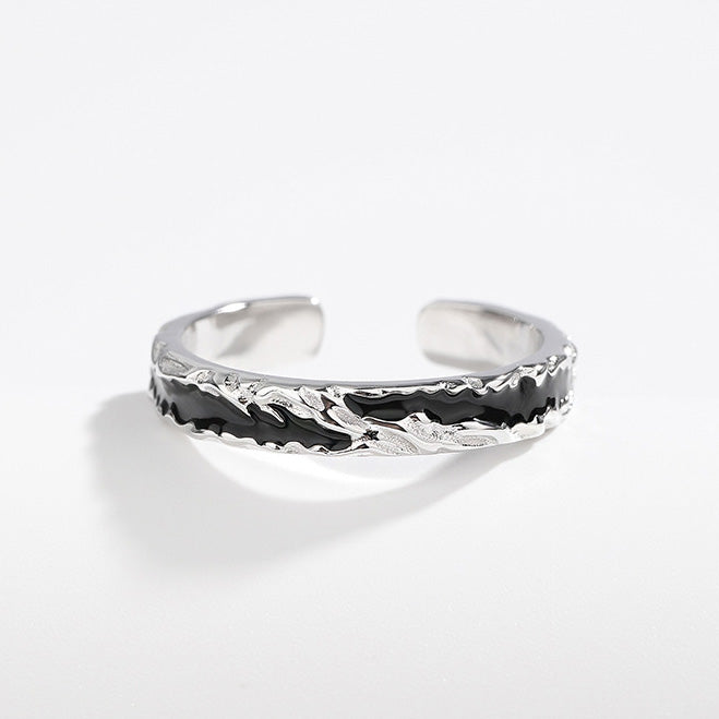 A close-up of a 925 sterling silver men's open ring with a distinctive black enamel inlay and a modern wavy design.