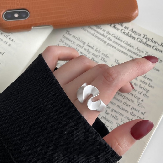 A model wearing the 925 Sterling Silver Irregular Lotus Leaf Matte Ring, showcasing its unique curved design and adjustable fit on the finger.