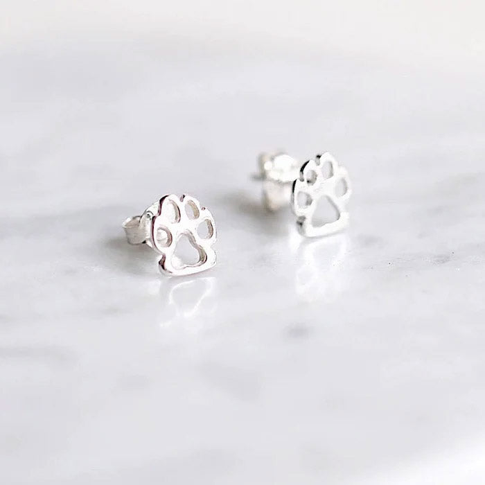 A pair of 925 sterling silver stud earrings shaped like dog paw prints, displayed on a white marble surface.