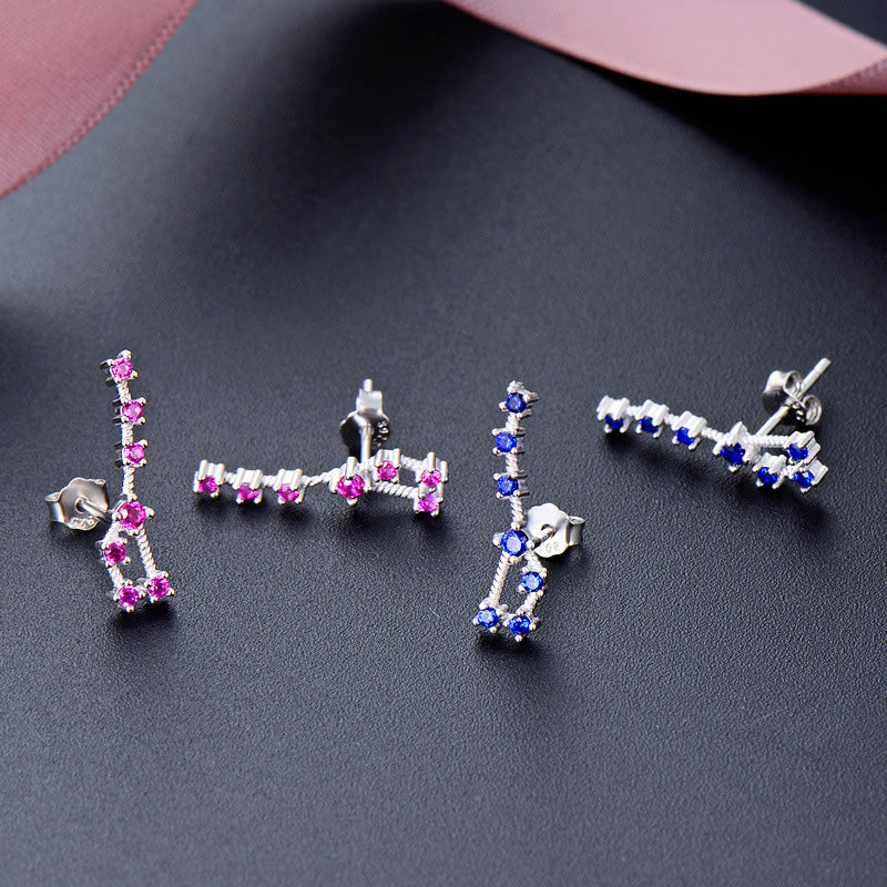 A set of 925 sterling silver Big Dipper stud earrings with sparkling pink and blue CZ stones, elegantly arranged on a dark background.