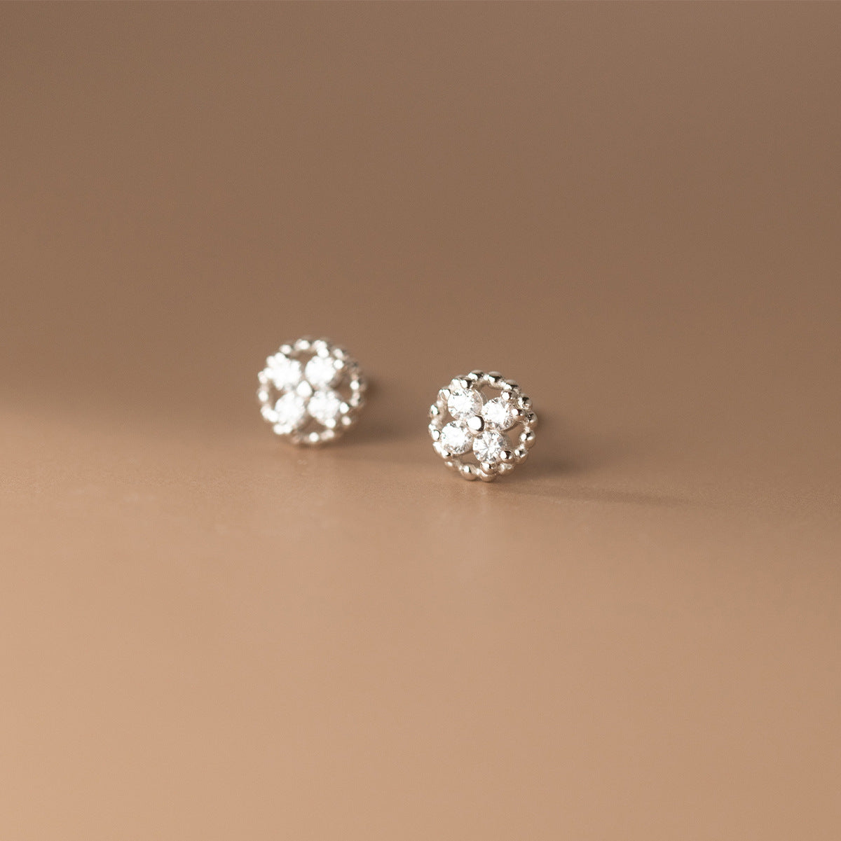 A pair of 925 sterling silver four-leaf clover stud earrings, intricately detailed with small, sparkling cubic zirconia stones.
