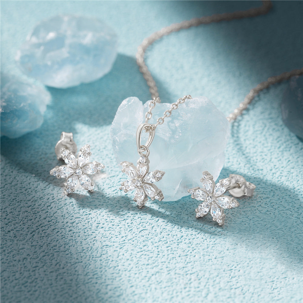 A stunning 925 sterling silver snowflake jewelry set, including a delicate necklace and matching stud earrings, adorned with sparkling clear gemstones.