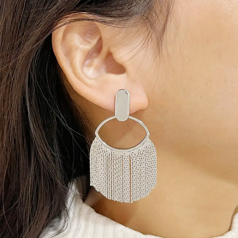 A close-up of a silver-plated tassel stud drop earring, showcasing its intricate fringe design against a white background.