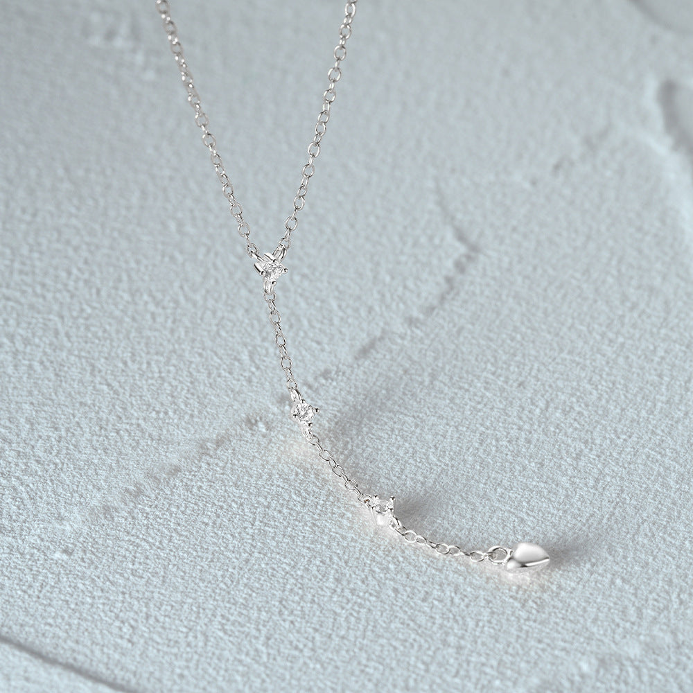 A close-up of the 925 sterling silver Y-shaped necklace, highlighting its minimalist design and distinctive heart-shaped charm clasp.