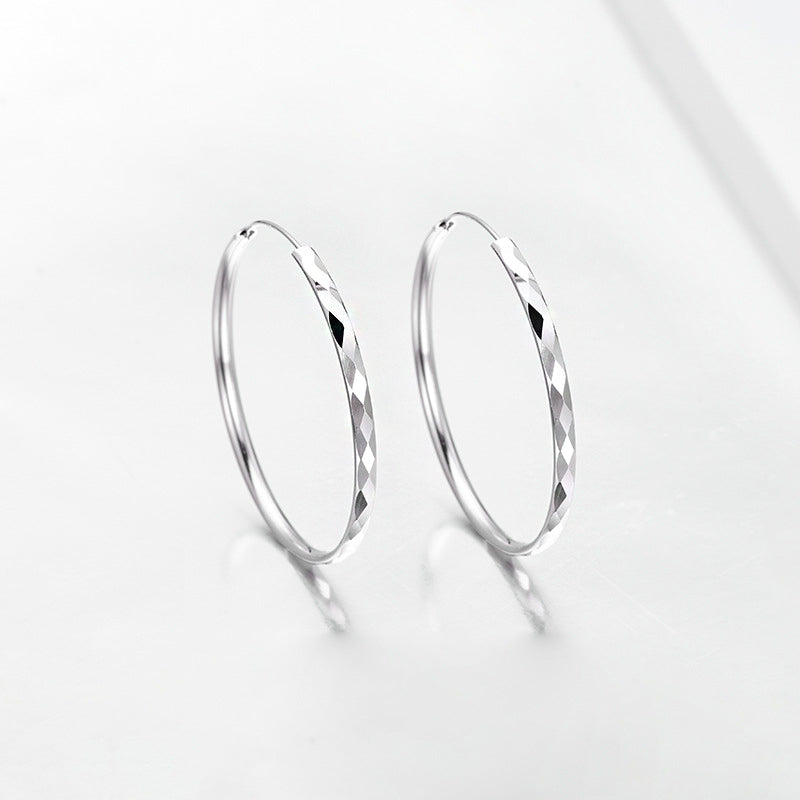 A close-up product shot of 925 sterling silver hoop earrings, featuring a detailed diamond-cut texture and a polished finish.