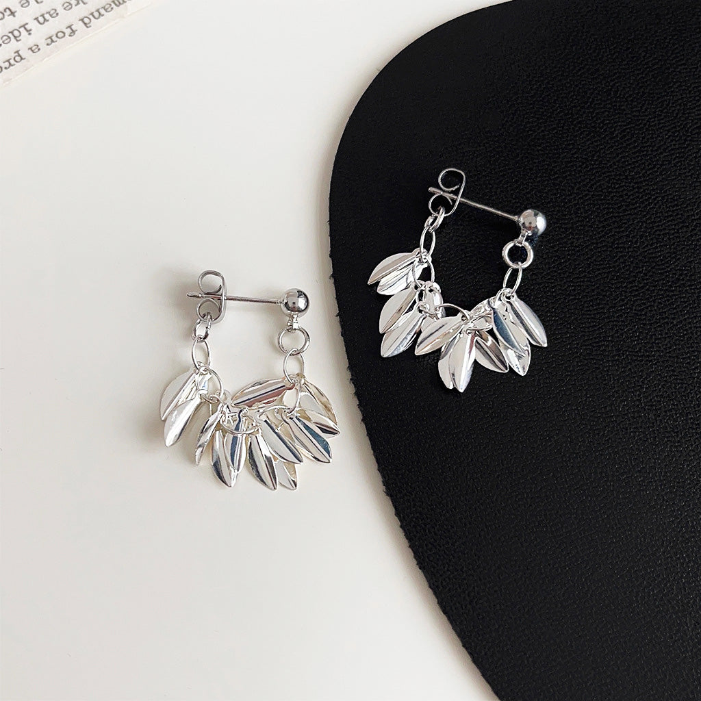 A pair of silver-plated leaf statement drop earrings with a multi-layered, dangling leaf design, displayed on a clean white background.