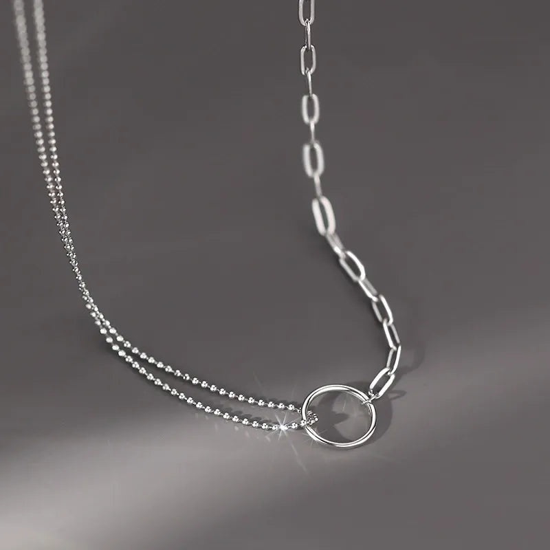 A clear product shot of the 925 sterling silver double-layer circle pendant necklace, showcasing its asymmetrical dual-chain design and elegant minimalist style.