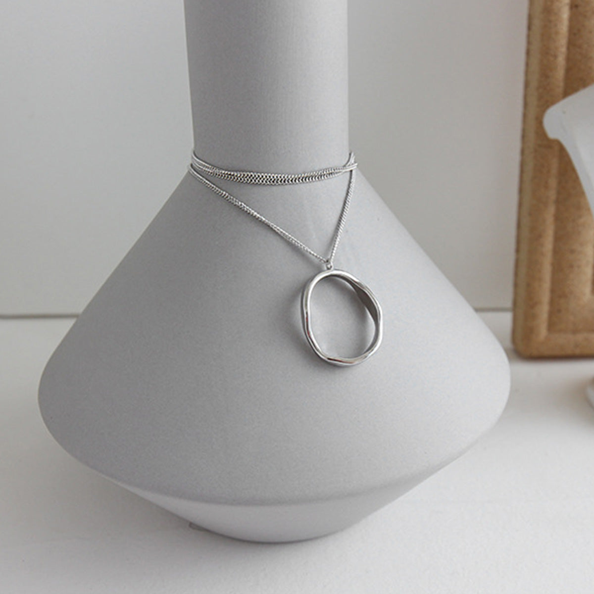 A close-up of the Korean Style Irregular Oval Pendant Necklace in 925 sterling silver, showcasing its minimalist design and polished finish.