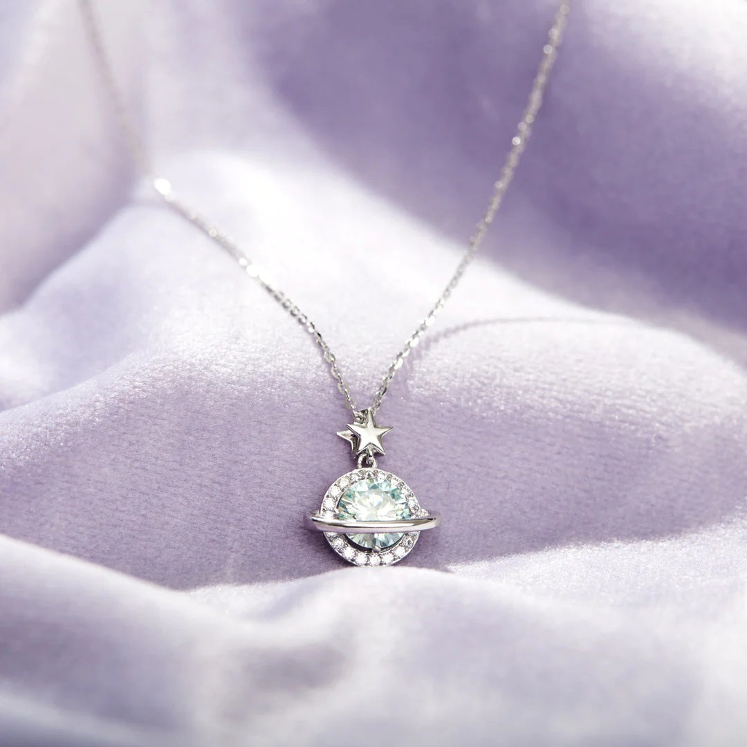 Close-up of the Shining Planet Zircon 925 Sterling Silver Cosmic Necklace, showcasing the detailed planet pendant with a pale blue-green gemstone and a star charm.