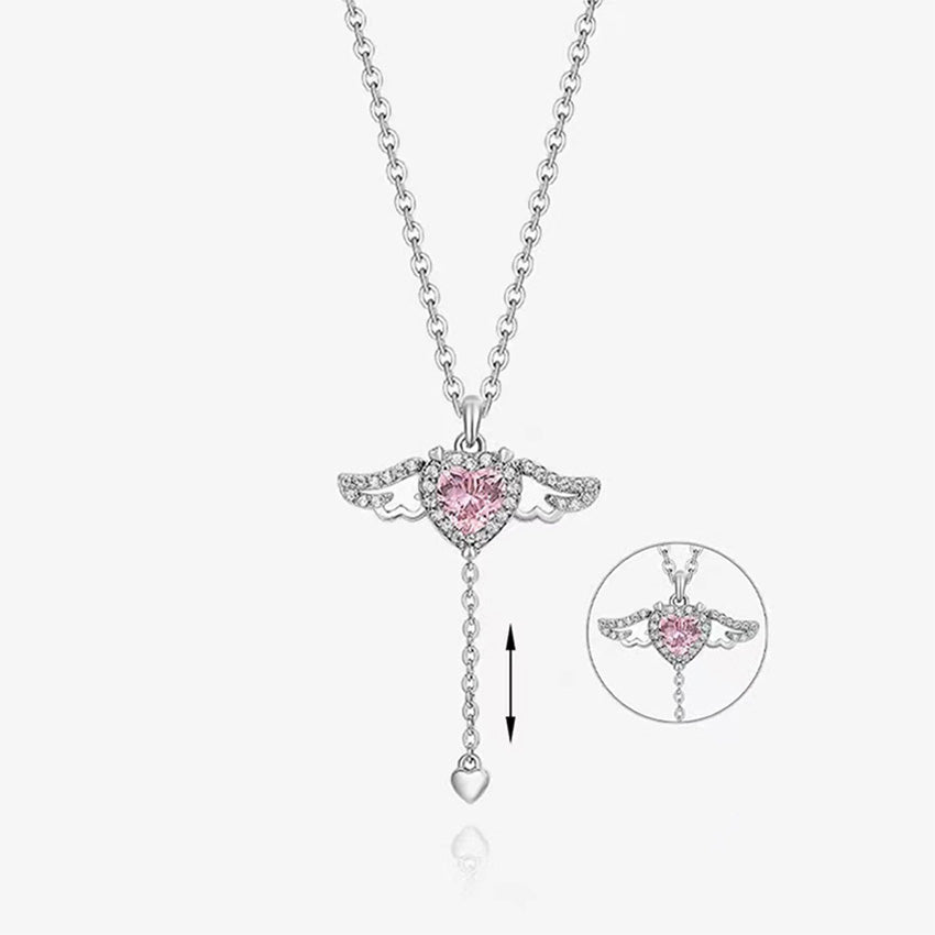 A close-up of the 925 sterling silver necklace featuring a delicate angel wing pendant cradling a brilliant pink heart-shaped gemstone.