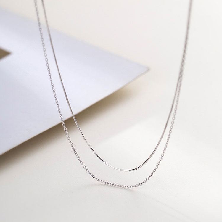 A set of 925 sterling silver double-layer necklaces, featuring a sleek snake chain and a classic link chain, displayed on a white background.