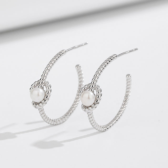 A pair of 925 sterling silver pearl knot rope C-shaped stud earrings on a clean white background.