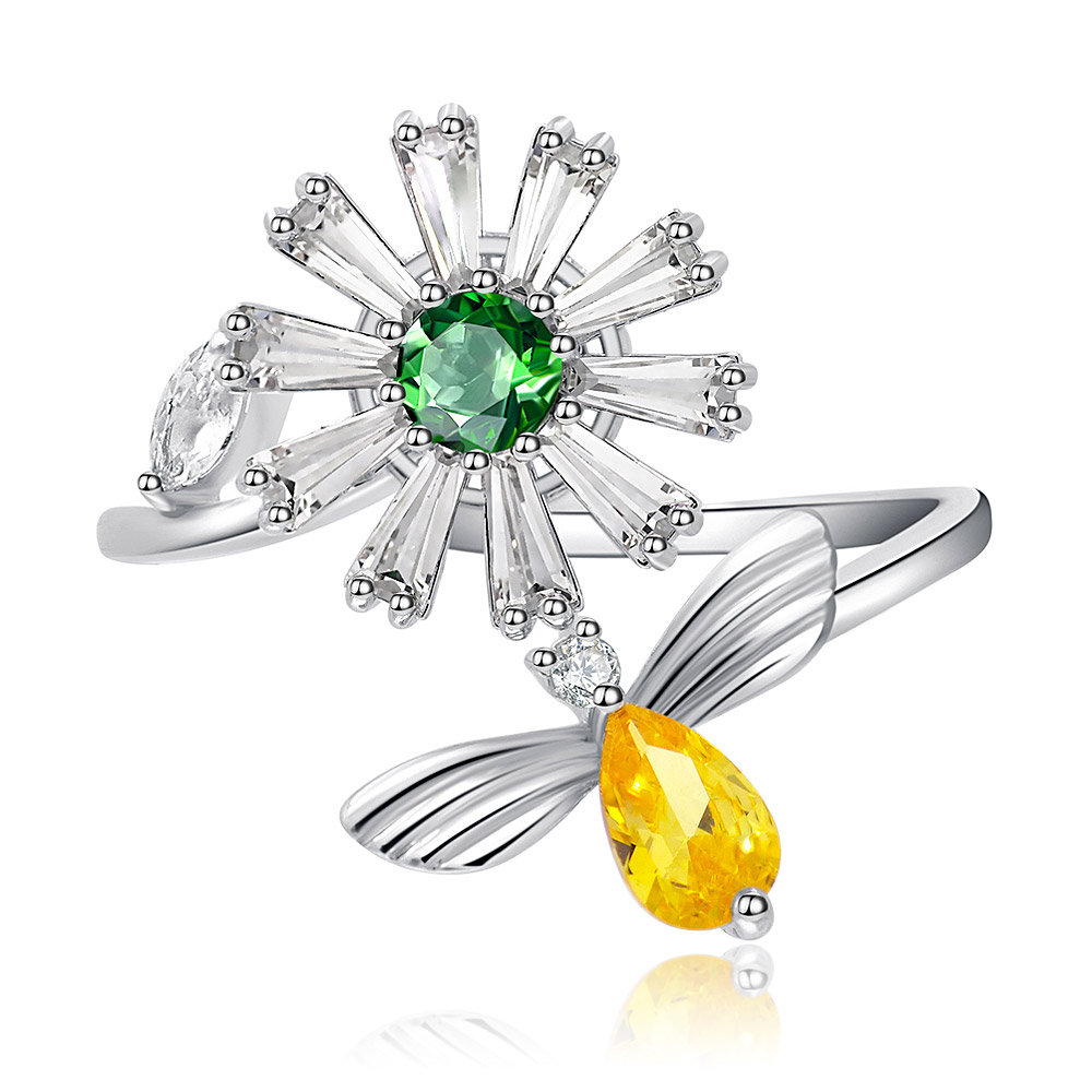 Close-up of the Spinning Flower Bee Ring, showcasing the central green CZ stone in a floral setting and a yellow CZ bee accent on a rhodium-plated brass band.