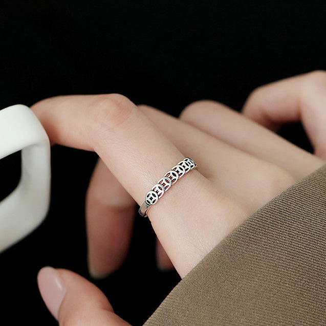 A close-up of a woman's hand wearing the 925 sterling silver lucky fortune vintage Chinese coin adjustable ring, showcasing its intricate design.