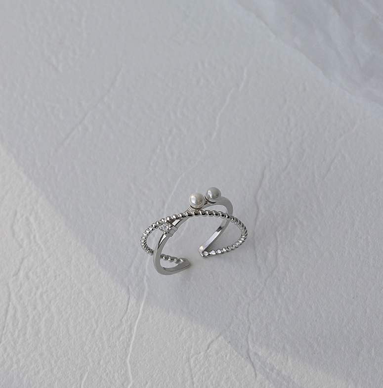 A close-up studio shot of the 925 Sterling Silver Pearl Cross Ring, showcasing its intricate design with two elegant pearls and sparkling cubic zirconia accents.