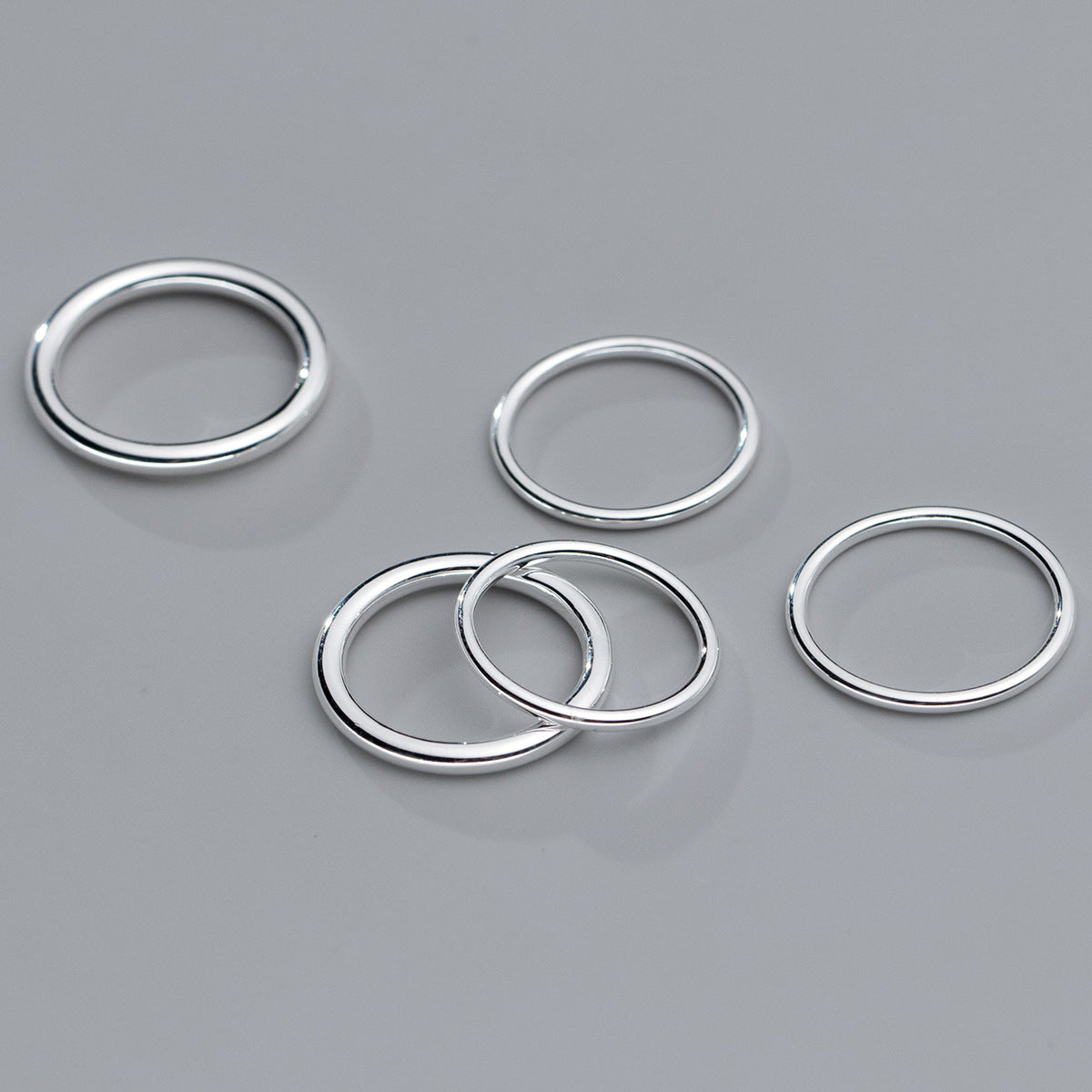 A set of five 925 sterling silver plain stackable rings with a sleek, modern design, shown against a neutral background.