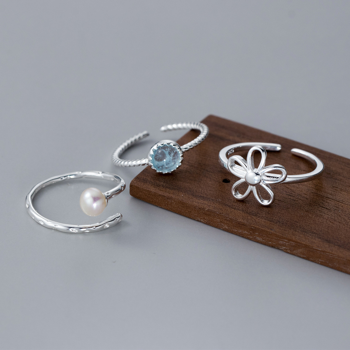 A collection of three adjustable 925 sterling silver rings from the flower ring set, featuring pearl, gemstone, and floral designs.