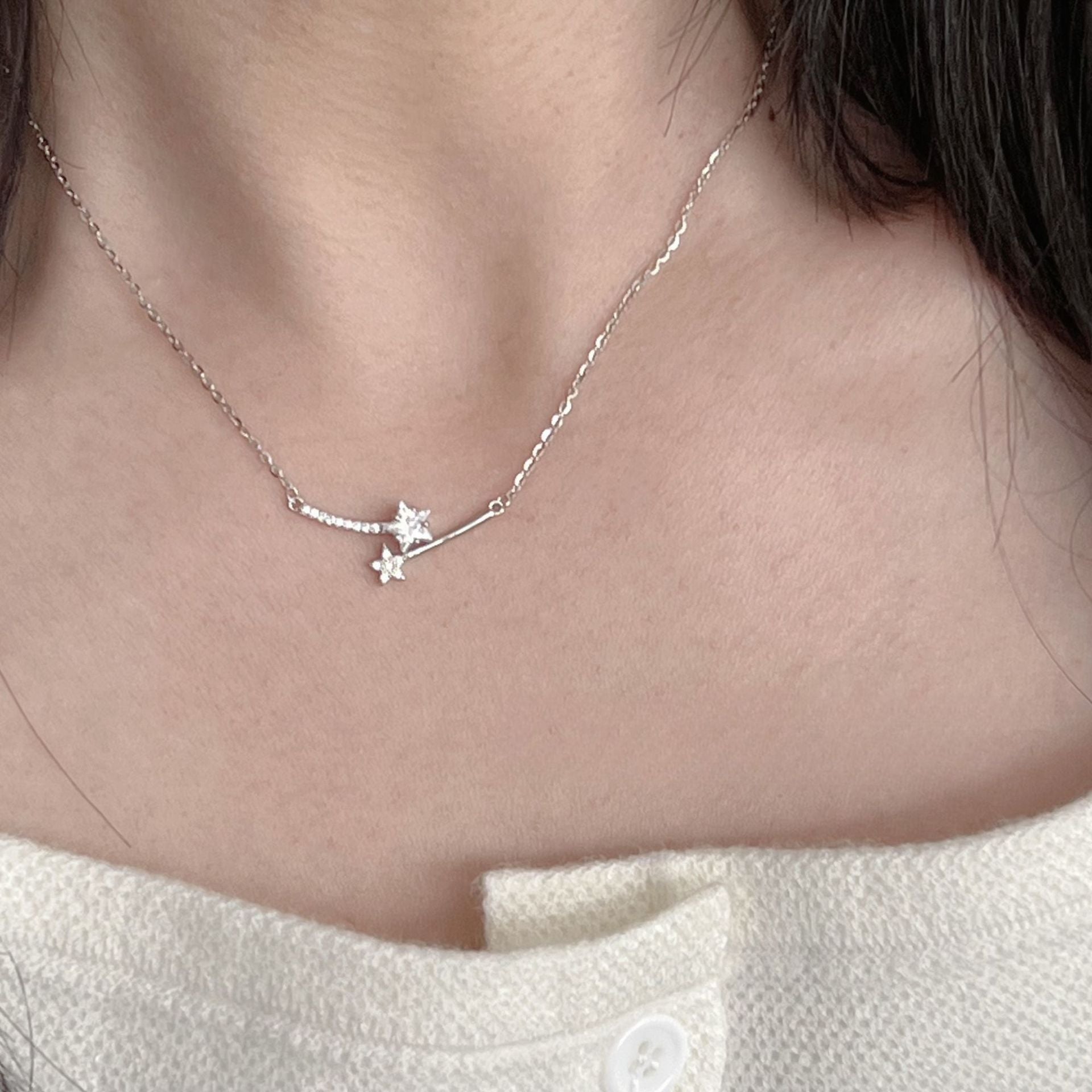 A close-up of a 925 sterling silver necklace from a set of five, featuring a star-flower shaped pendant with cubic zirconia, plated in platinum.