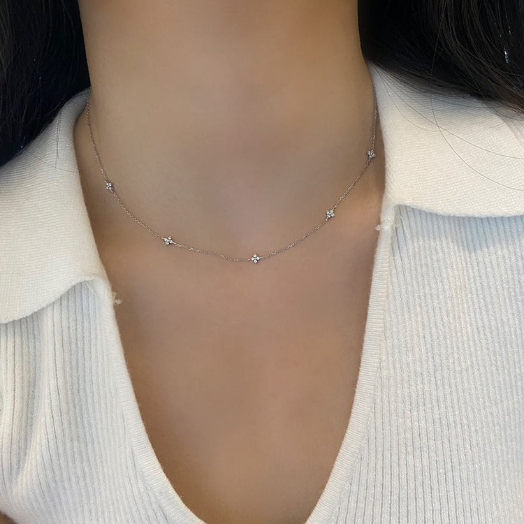A model wearing an elegant 925 sterling silver star-themed necklace with 18K gold plating and cubic zirconia, part of a five-piece set.