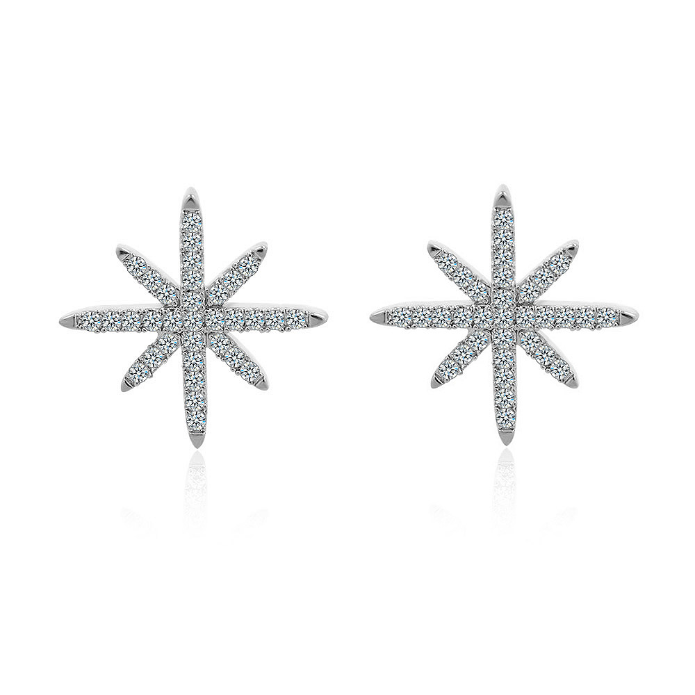 A pair of silver starburst stud earrings in rhodium, featuring an eight-pointed star design set with sparkling cubic zirconia stones, shown on a white background.