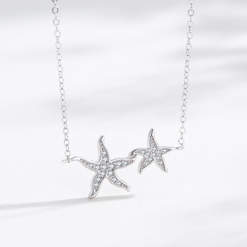 A detailed view of the 925 Sterling Silver Starfish Pendant Necklace, highlighting the two pendants adorned with brilliant clear zirconia gemstones.