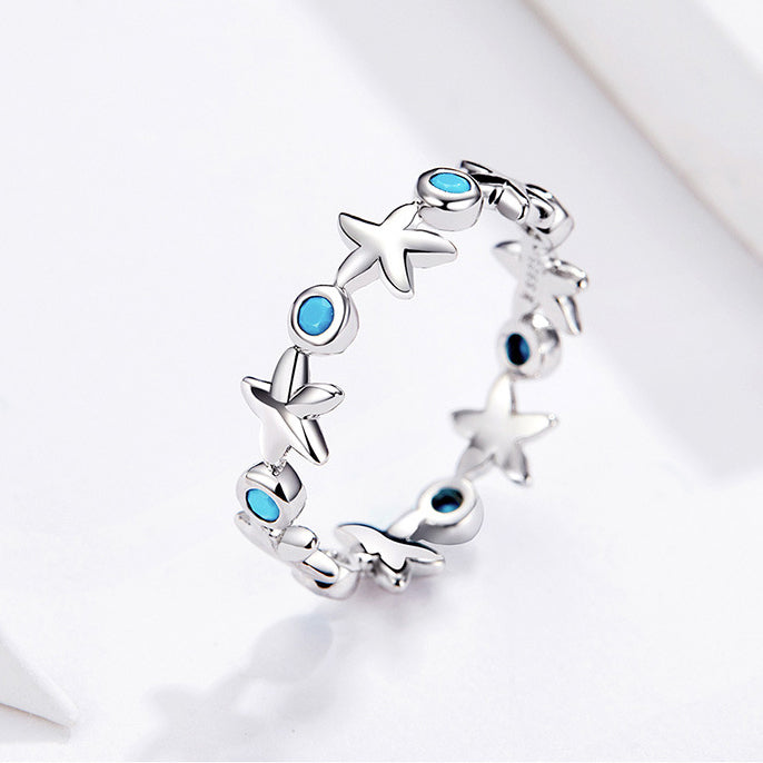 A set of five 925 sterling silver rings with an ocean-inspired starfish design, adorned with sparkling ocean-blue zircon stones, displayed on a neutral background.