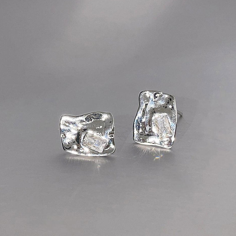 A pair of silver-plated stud earrings with a unique, textured, and irregular wavy design, part of a 5-pair set.