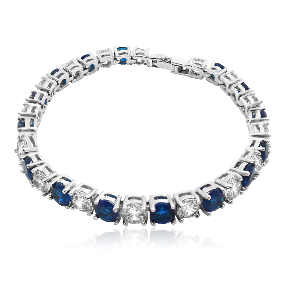A stunning Sapphire White Wholesale Tennis Bracelet with alternating round-cut blue sapphire and white cubic zirconia stones, set in a high-polish rhodium-plated silver-toned metal, shown on a clean white background.