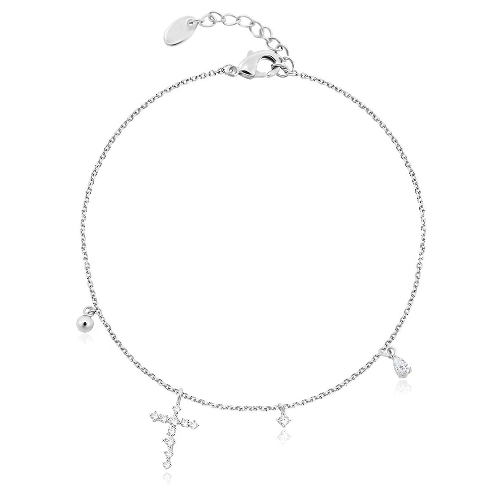 A detailed view of the Tiny Cross Bracelet, showcasing its rhodium-plated brass chain and multiple charms, including a cubic zirconia-studded cross.