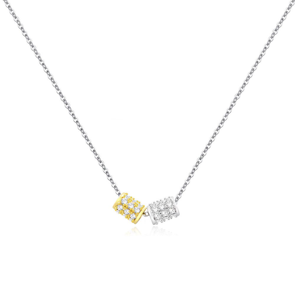 Close-up of the Two-Tone Geometry Necklace, showcasing its dual gold and silver pendants set with sparkling white cubic zirconia stones against a white background.